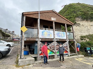 A lady and gentleman stand in front of the Fine Foundation centre in Beer, Devon